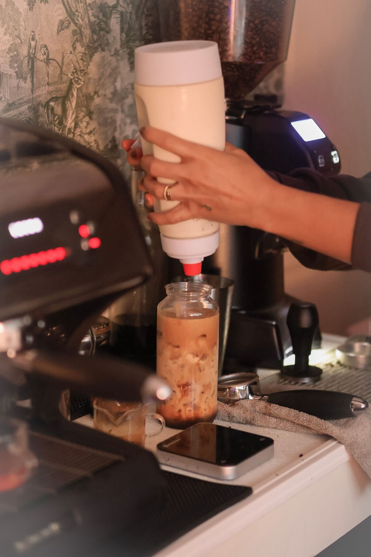 Pouring house-made syrup into a fresh drink